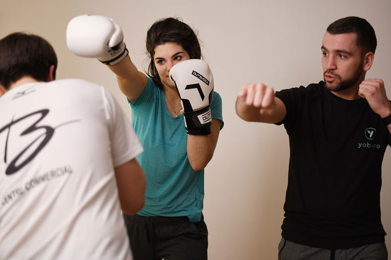 2 hommes et une femme pratiquant de la boxe
