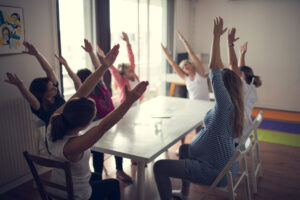 Groupe d'employé pratiquant le yoga sur chaise dans un bureau