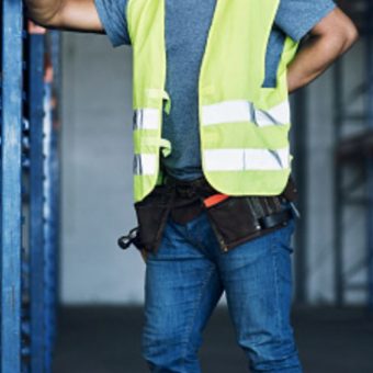 Homme en tenue de travail portant un gilet jaune dans un entrepôt